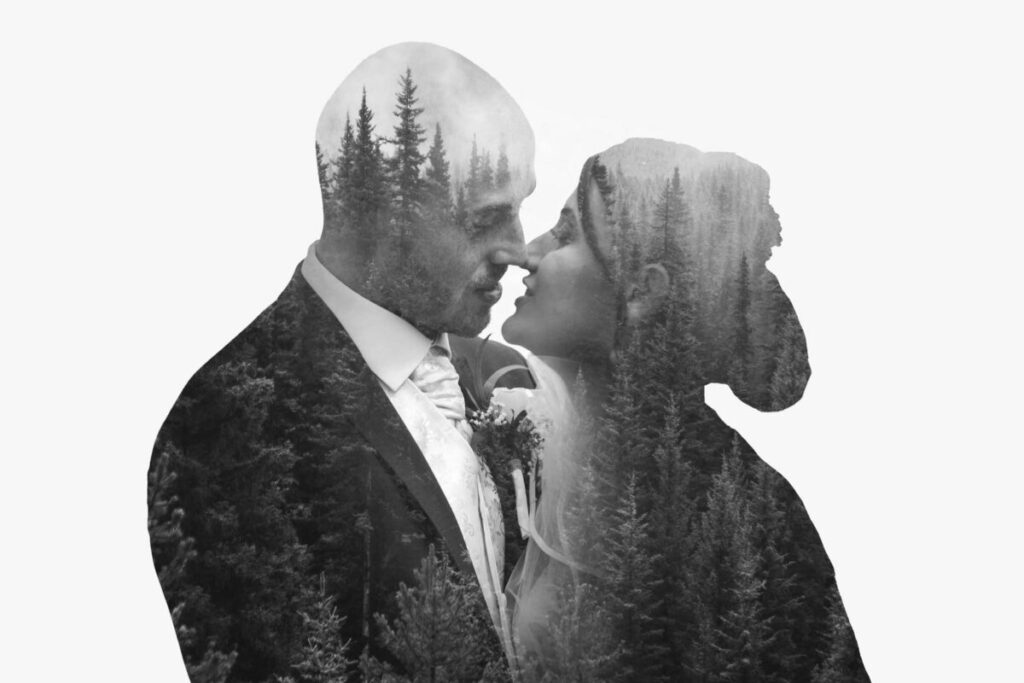 A silhouette of a couple kissing in the woods.